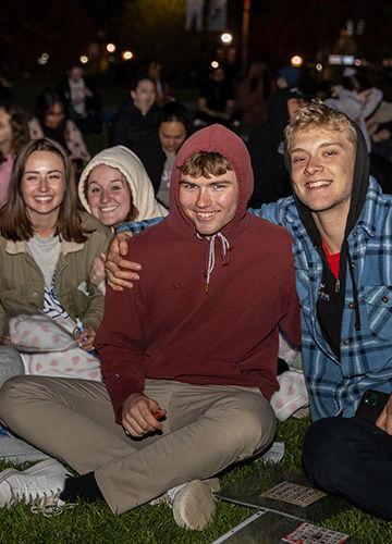 Four students smile, with their arms around each other, at Big A Bingo on the Boyden lawn